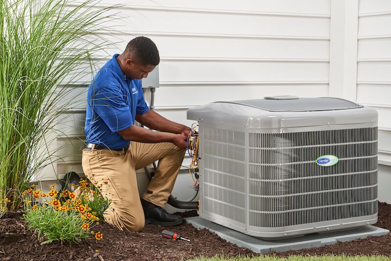 HVAC Specialist performing annual maintenance on the central air conditioner compressor