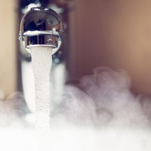 A close-up of hot water running from the faucet.