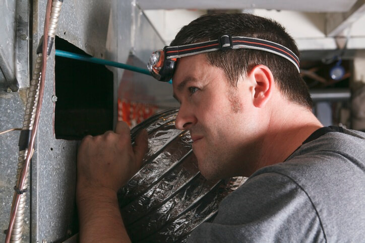 HVAC Specialist performing routine maintenance on a customers heating system.