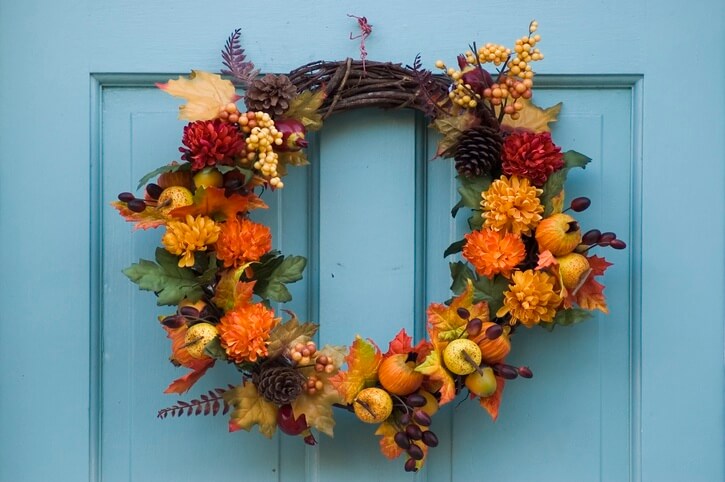 A decorative autumn wreath hangs from a door.