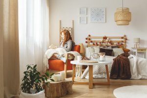 woman sits in a chair reading in a cozy room