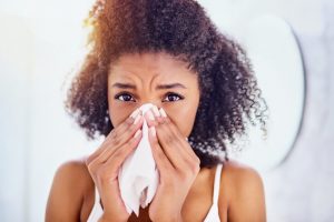 woman blowing nose into tissue