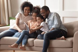 family sits on couch and enjoys comfortable home