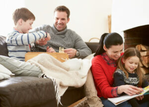 family sits in living room enjoying games and reading