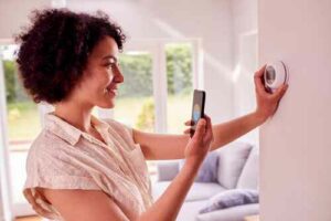 woman adjusting thermostat