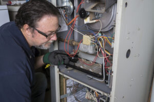 Technician inspecting a gas furnace