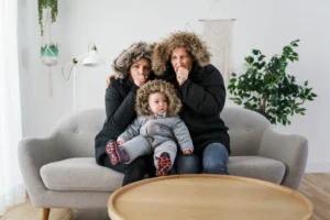 Family wearing winter coats in their home