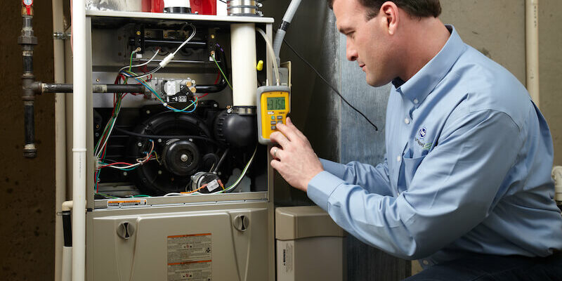 hvac technician works on furnace